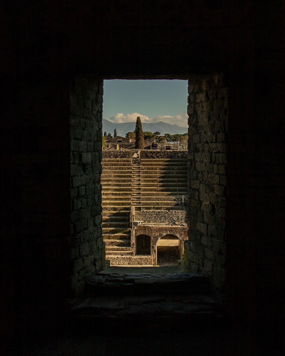pompeii italy ruins and trees framed by stone window
