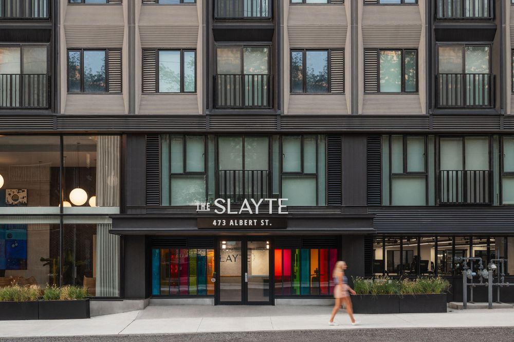Modern apartment building exterior with The Slayte signage and colorful entrance.