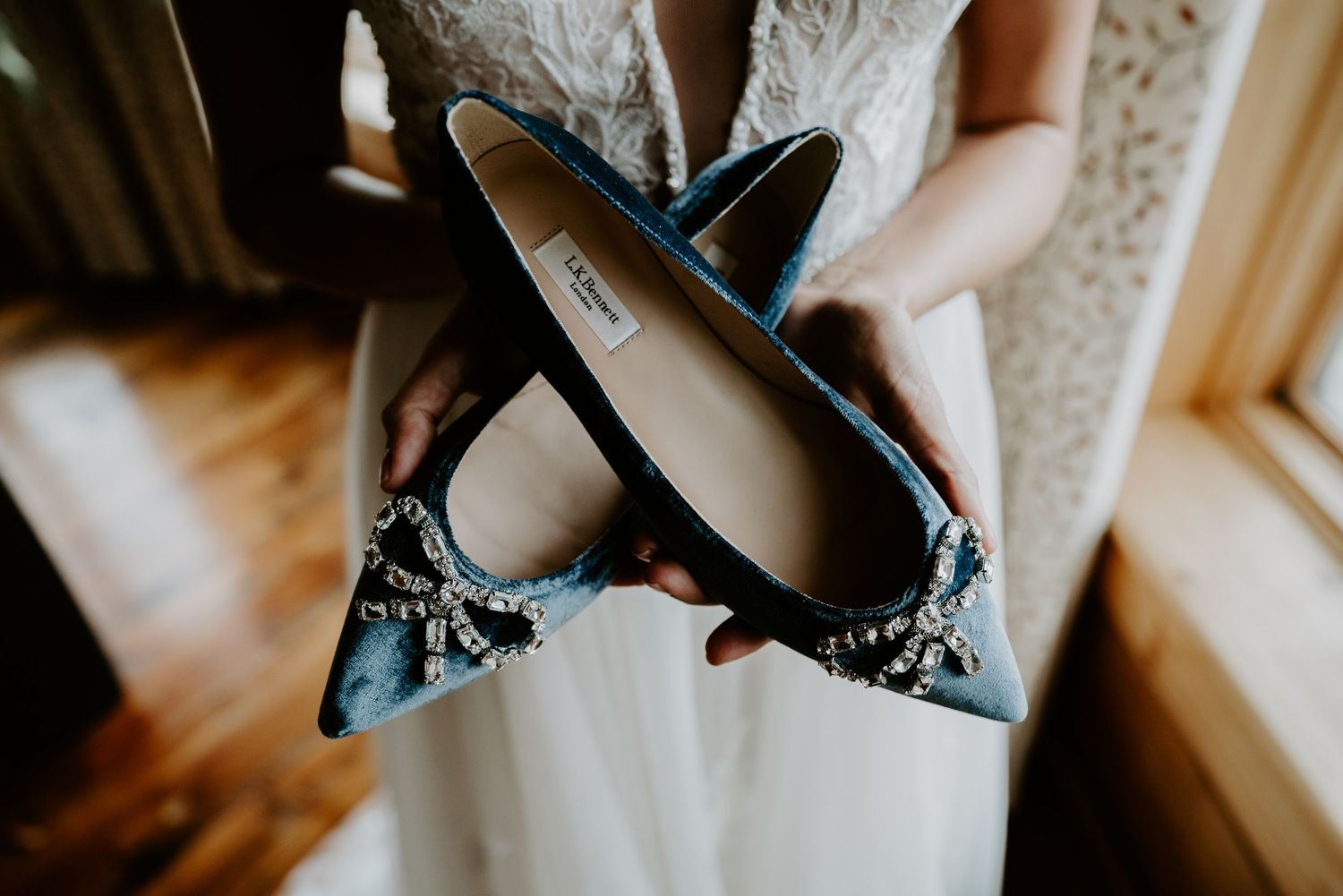 Bride holding her blue velvet wedding shoes