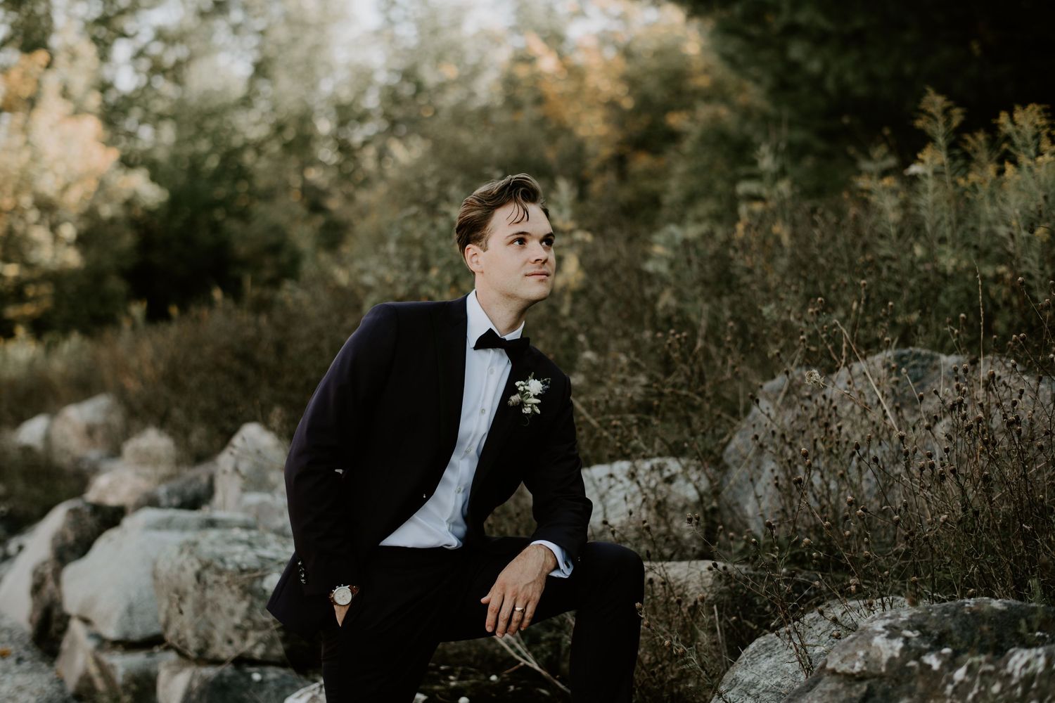 groom gazing by rocks