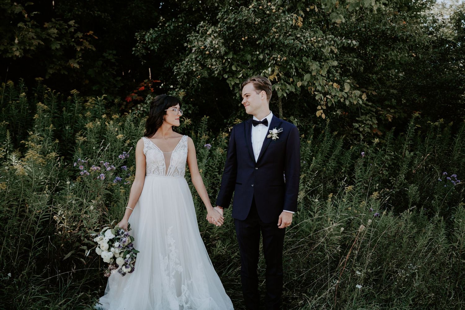 bride and groom holding hands and gazing at one another