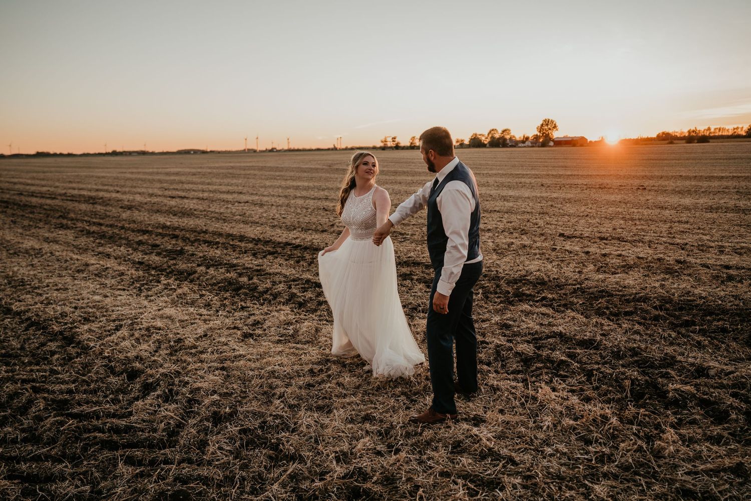bride and groom sunset dance in field