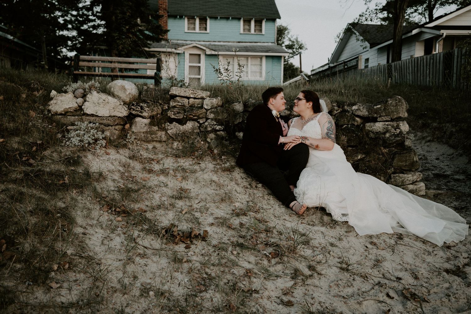 bride and bride sitting by blue house