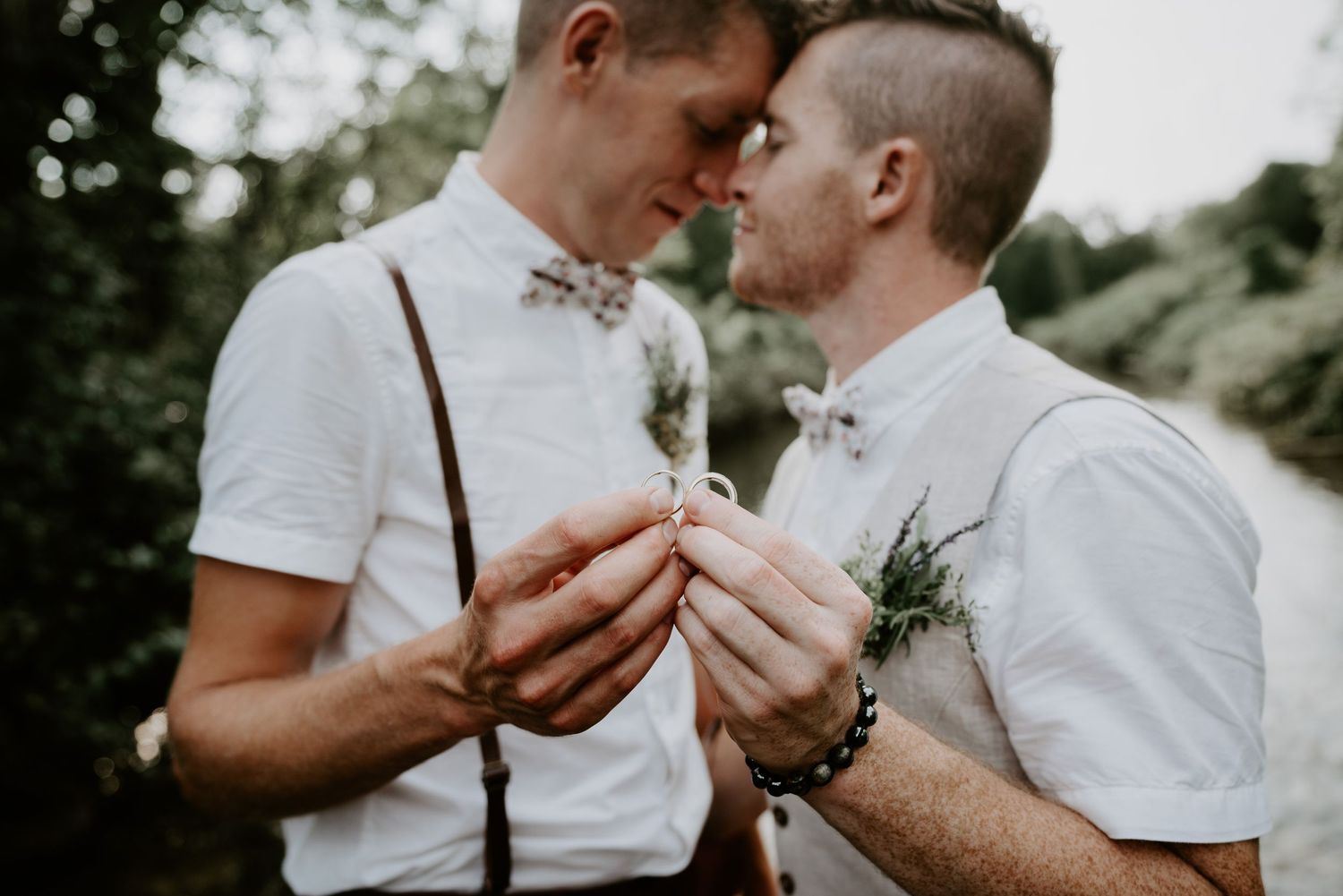 groom and groom holding rings together