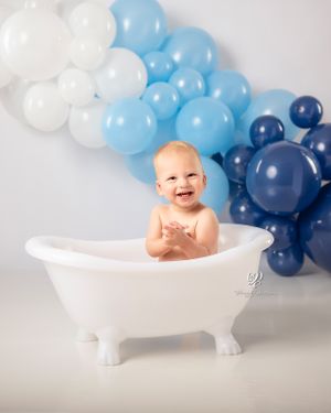 Smiling baby boy birthday photos; blue balloons, white balloons; Lexington, SC photography studio; Cake Smash birthday