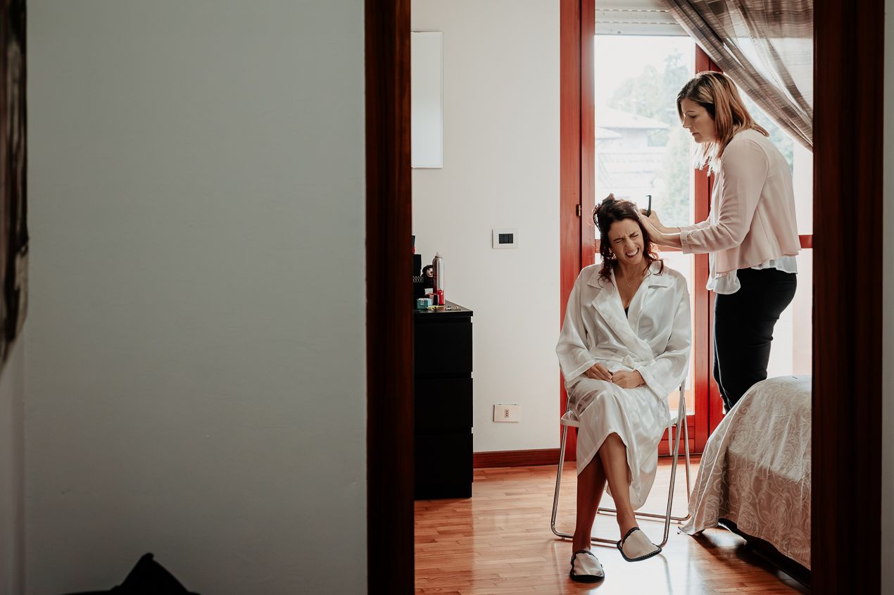 Behind-the-scenes moment of wedding day preparation in a bright room.
