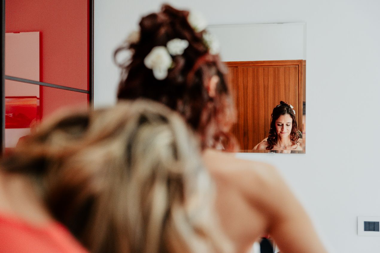 Reflection of wedding preparation in a mirror with warm wooden tones.