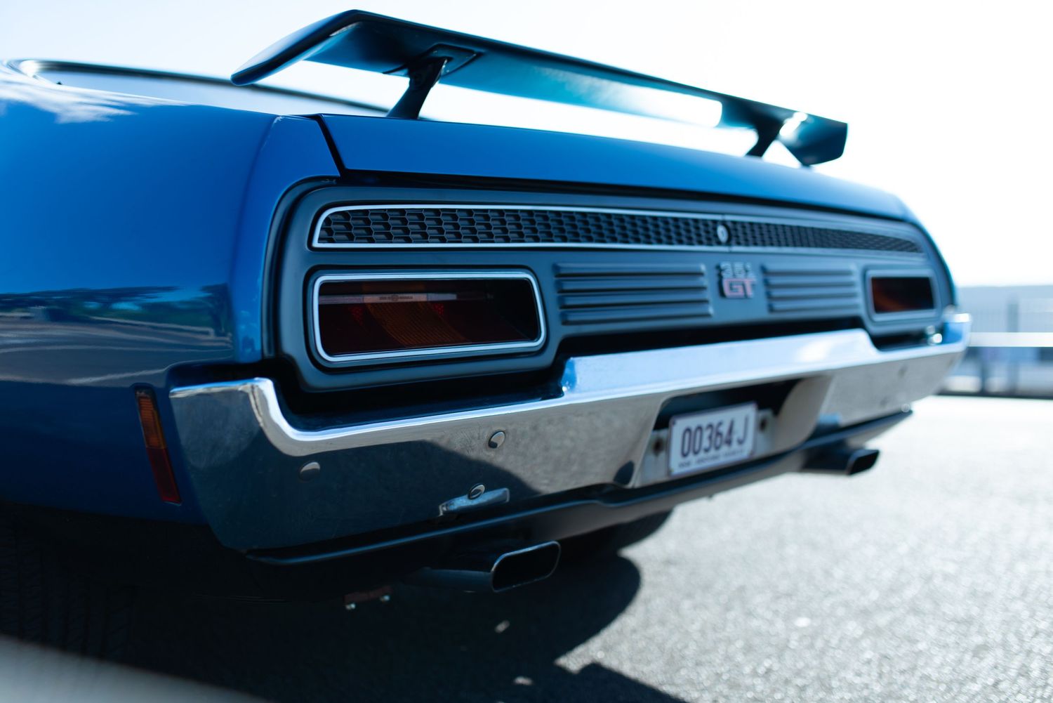 Close up of rear quarter panel showing vintage taillights and chrome trim.