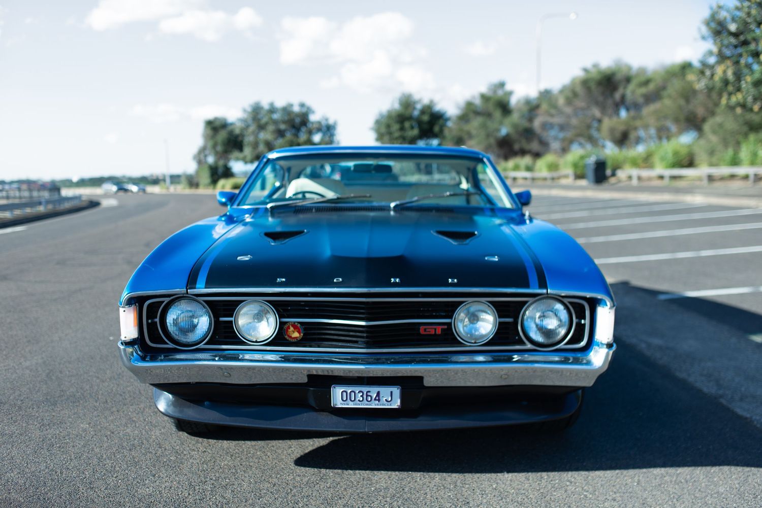 Classic blue Ford muscle car with distinctive front grille and headlights.