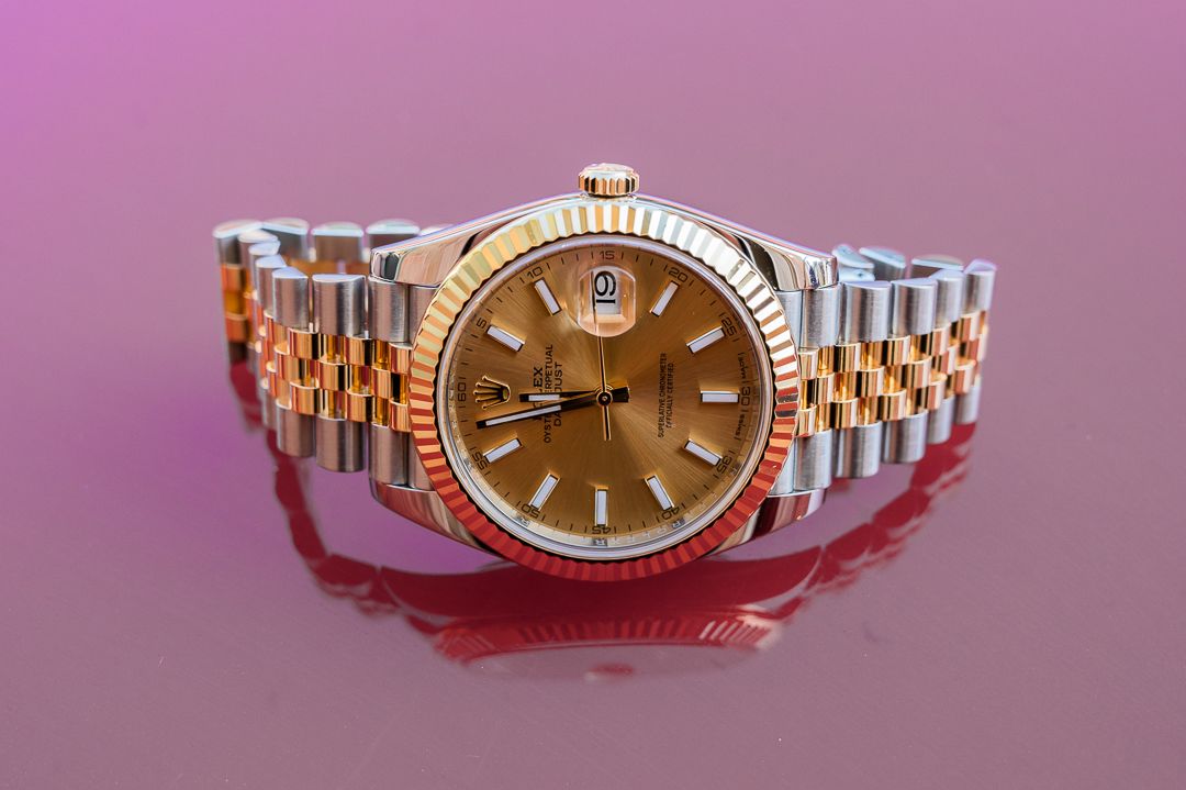 Two-tone Rolex with rose gold accents on purple background.