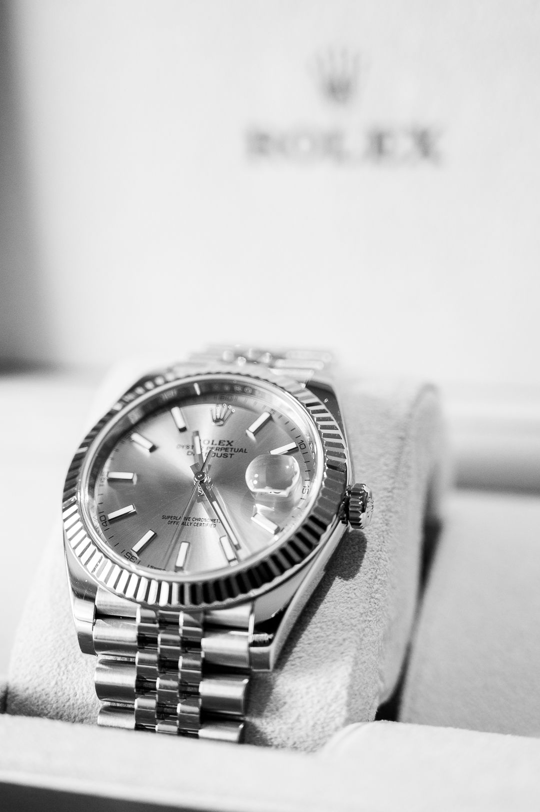 Classic Rolex Datejust watch with silver dial and jubilee bracelet displayed on white cushion.