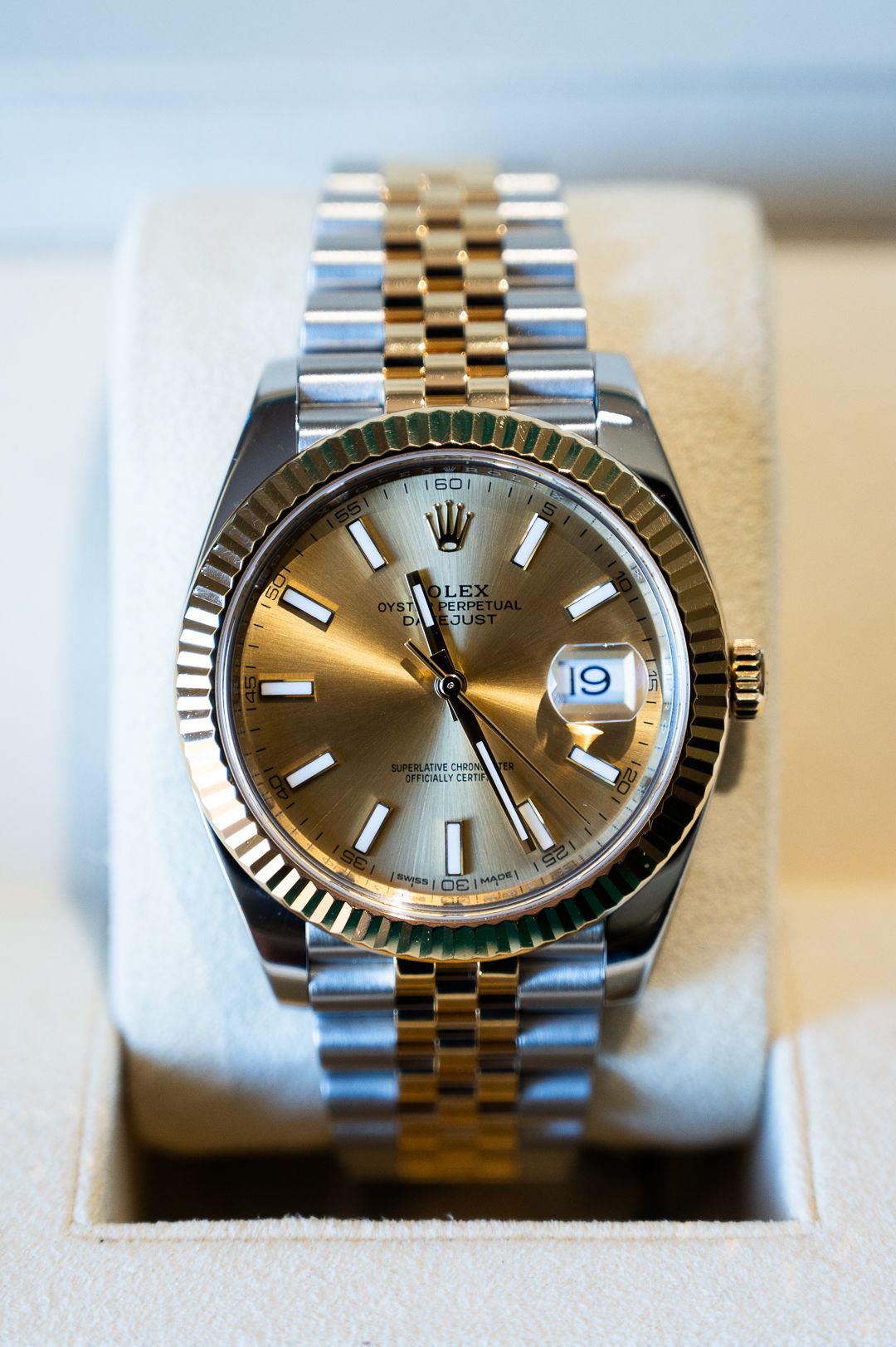 Gold and steel two-tone Rolex with fluted bezel and champagne dial.