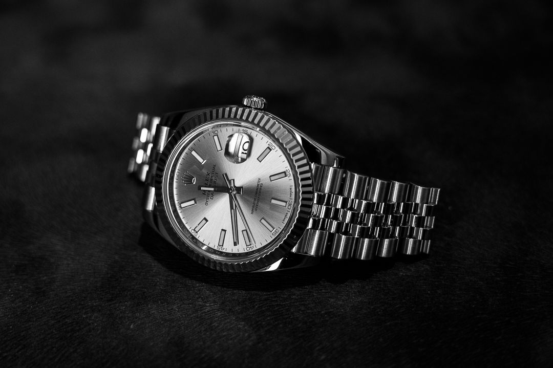 Dramatic black and white shot of Rolex watch with fluted bezel.