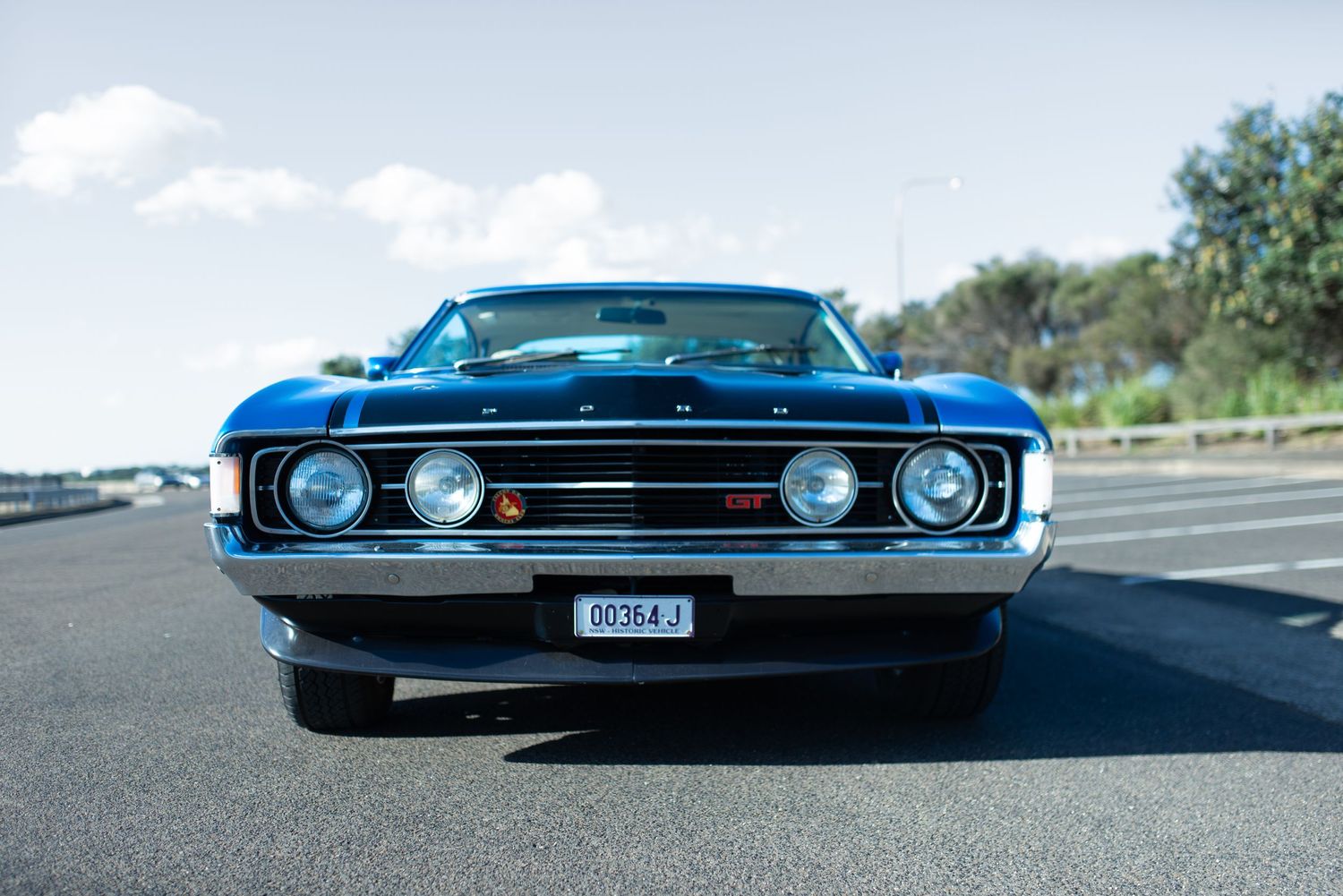 Vintage blue Ford Torino GT muscle car photographed from front view.