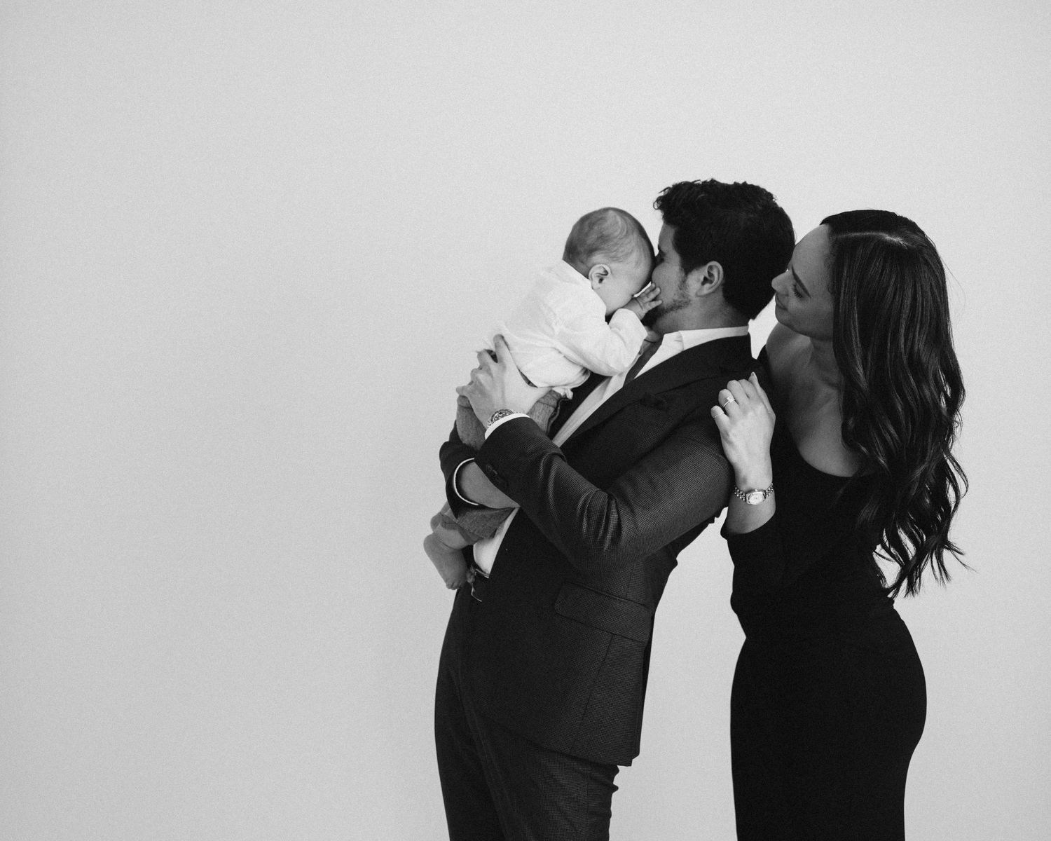 An elegant black and white family portrait against a simple backdrop.