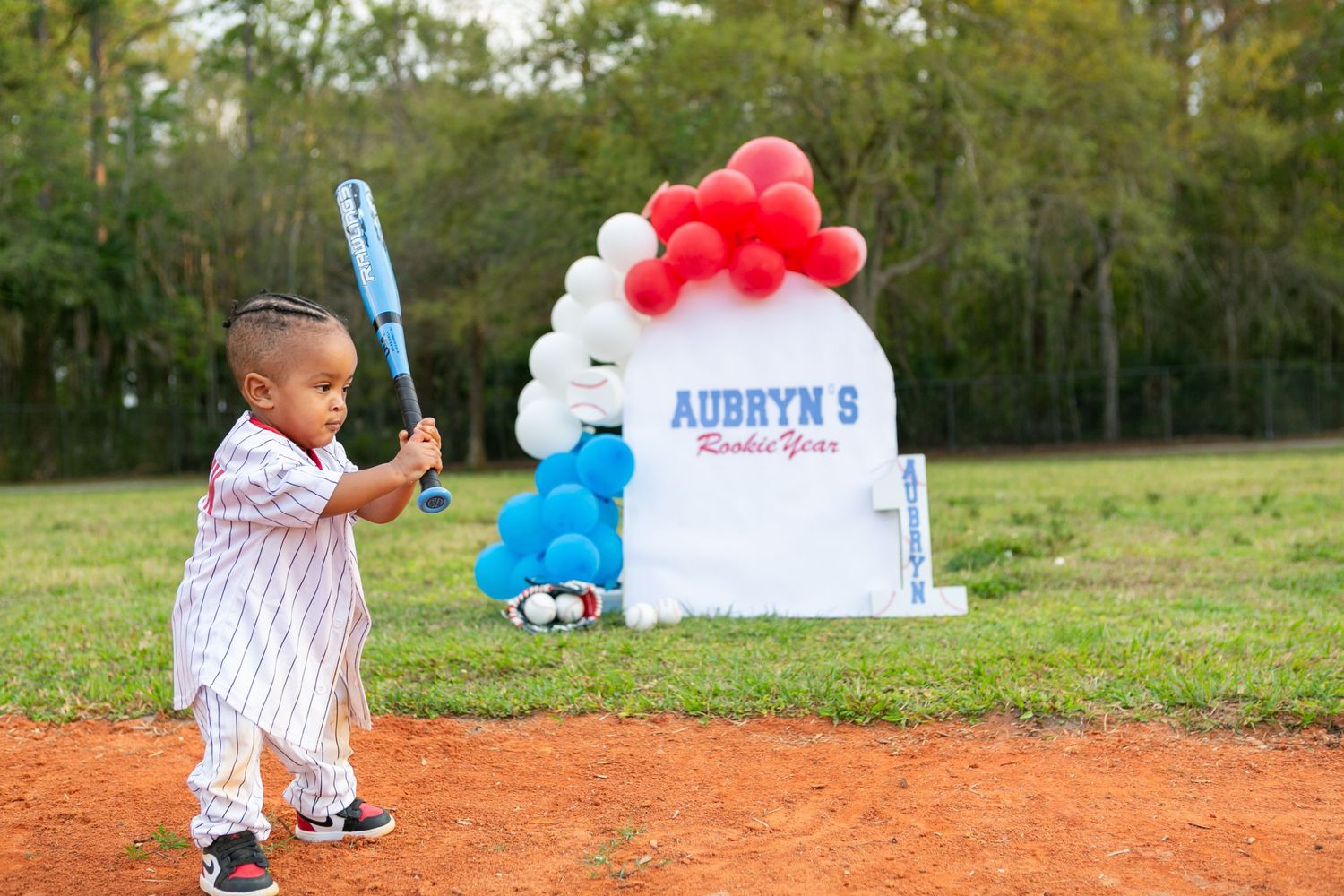 Sanford FL Cake Smash Photography boy holding a baseball bat for baseball theme birthday