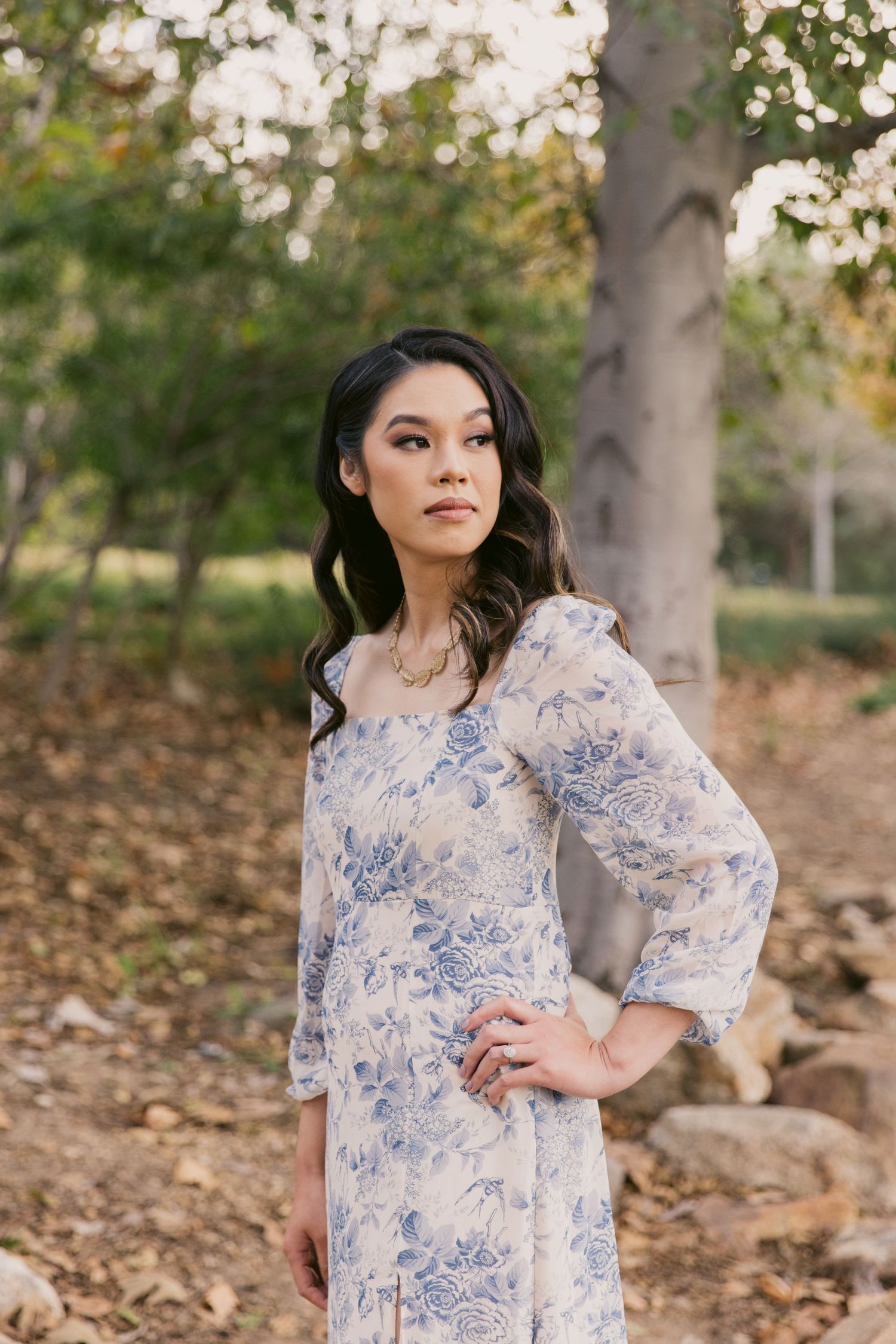 Portrait session featuring a blue and white floral dress in a natural outdoor setting.
