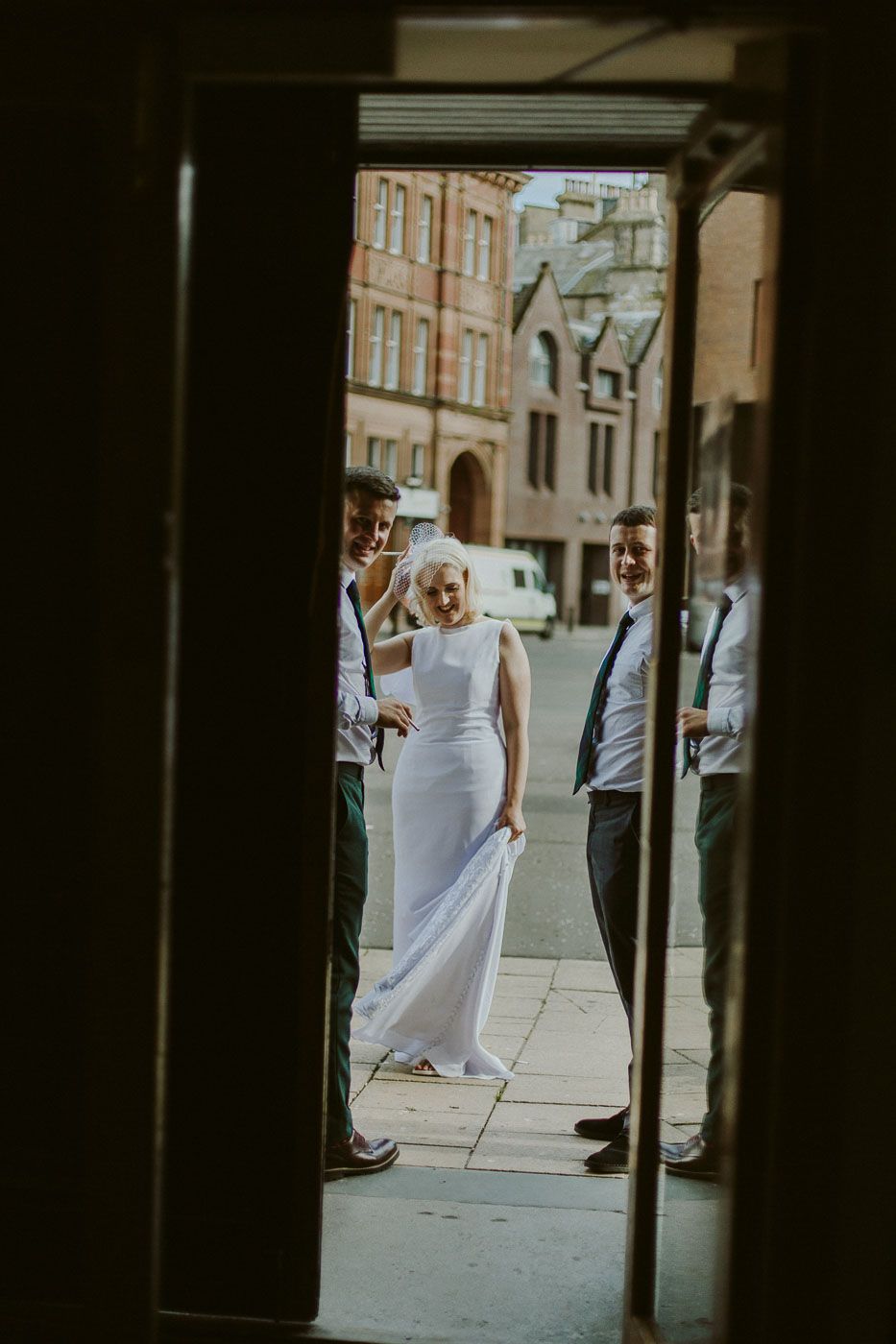 Elegant figure in white dress standing in doorway of historic building.
