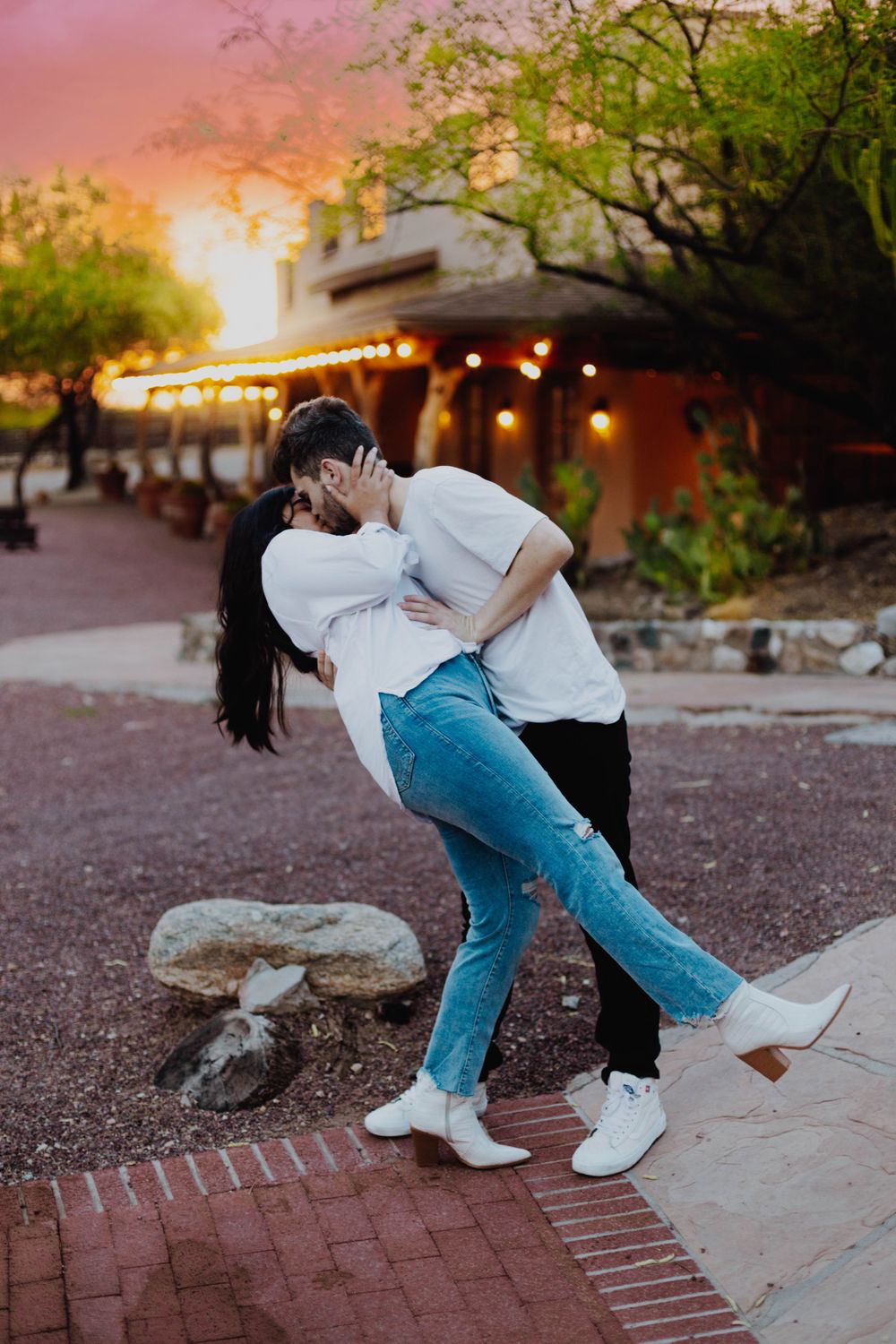 Playful dance dip poses at sunset in a desert garden setting.
