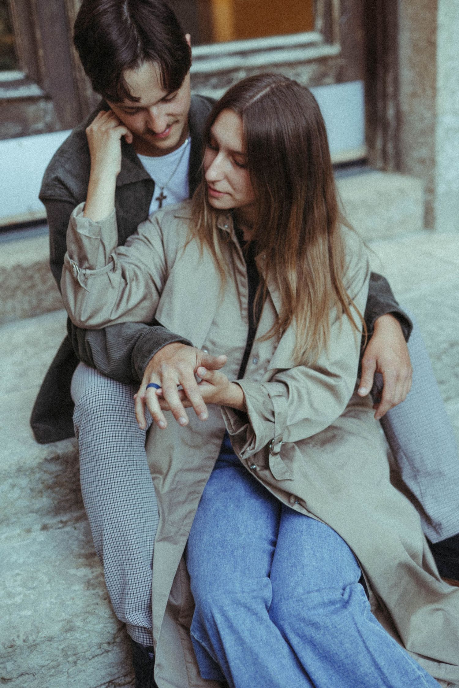 Couple in casual outfits sharing an intimate moment on urban steps.