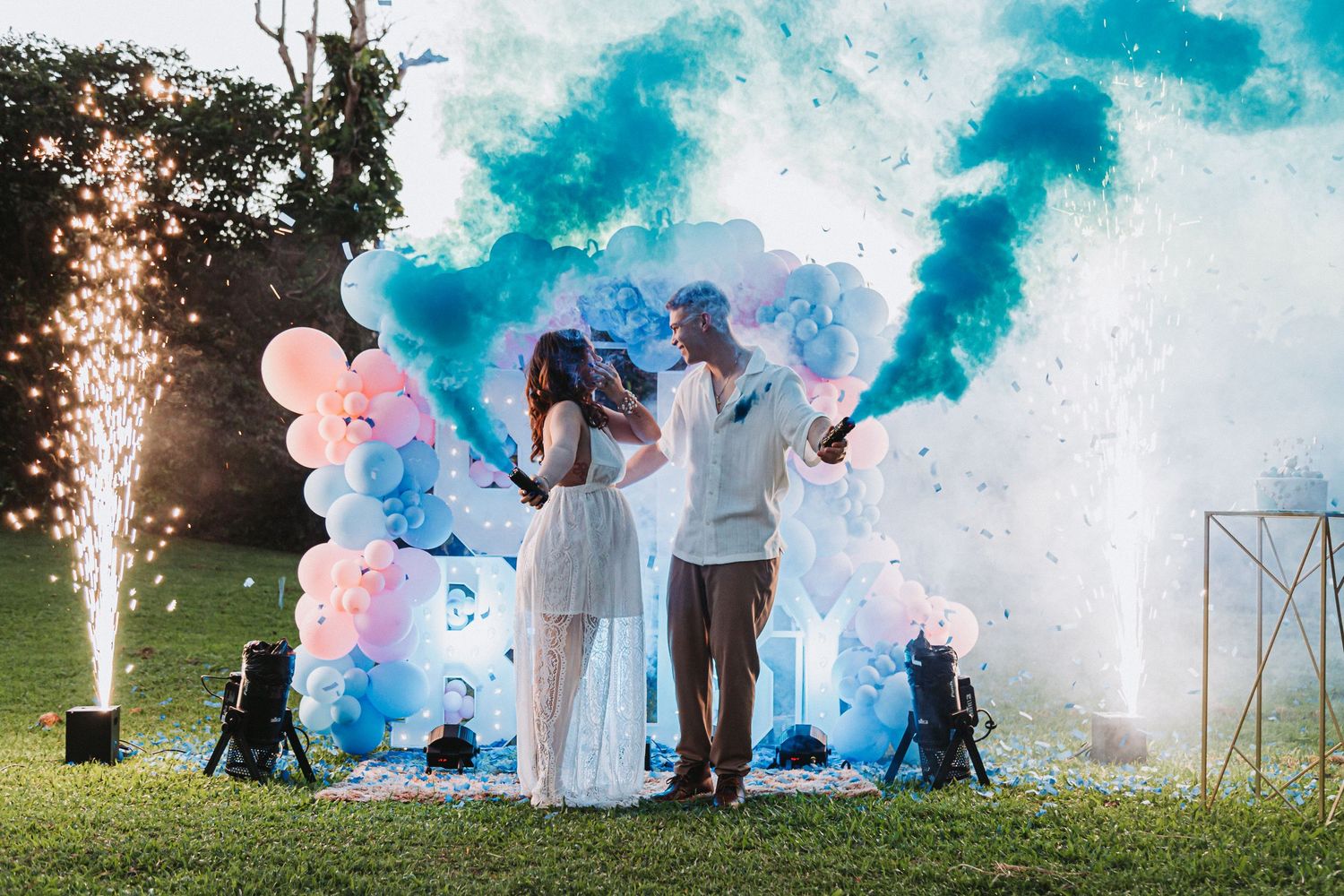 Wedding celebration with blue smoke bombs and sparklers creating dramatic outdoor photo effect.