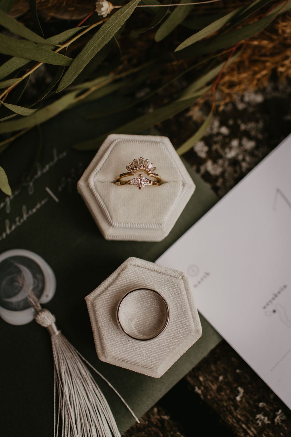 Engagement rings nestled in hexagonal velvet ring boxes with a decorative tassel.