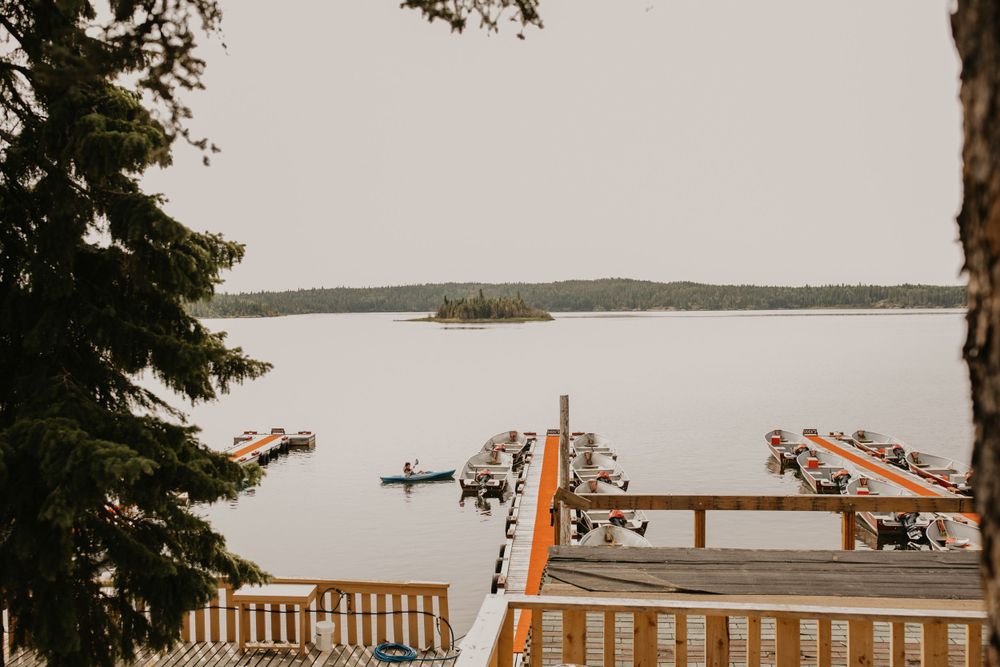 Scenic lakeside dock view with wooden deck and boats in the distance.
