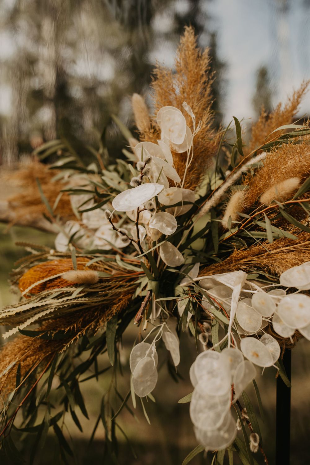 A detailed shot of dried pampas grass and white floral elements in a wedding arrangement.