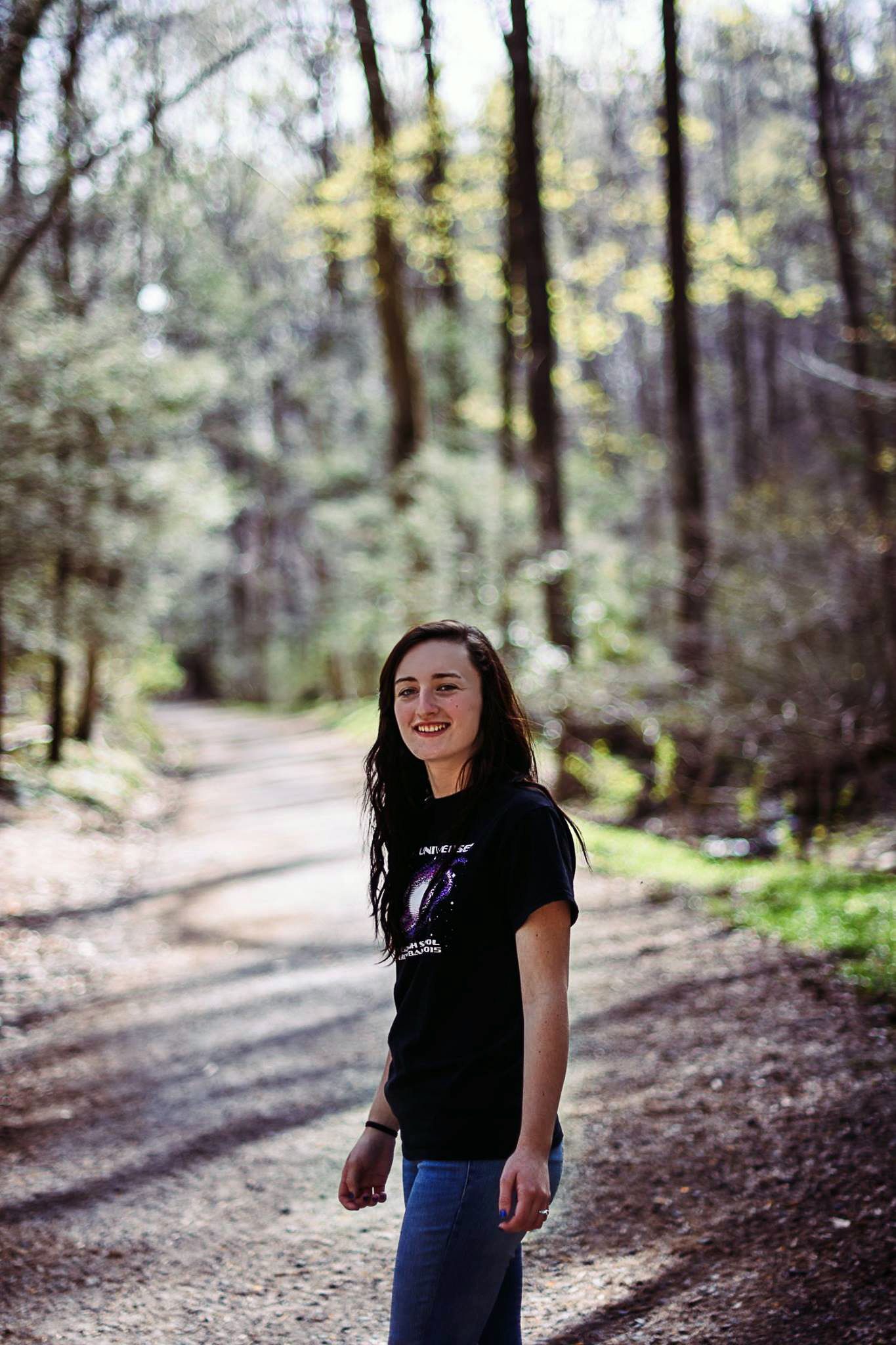 A sequence of candid shots in a wooded forest path showing joyful movement and laughter.