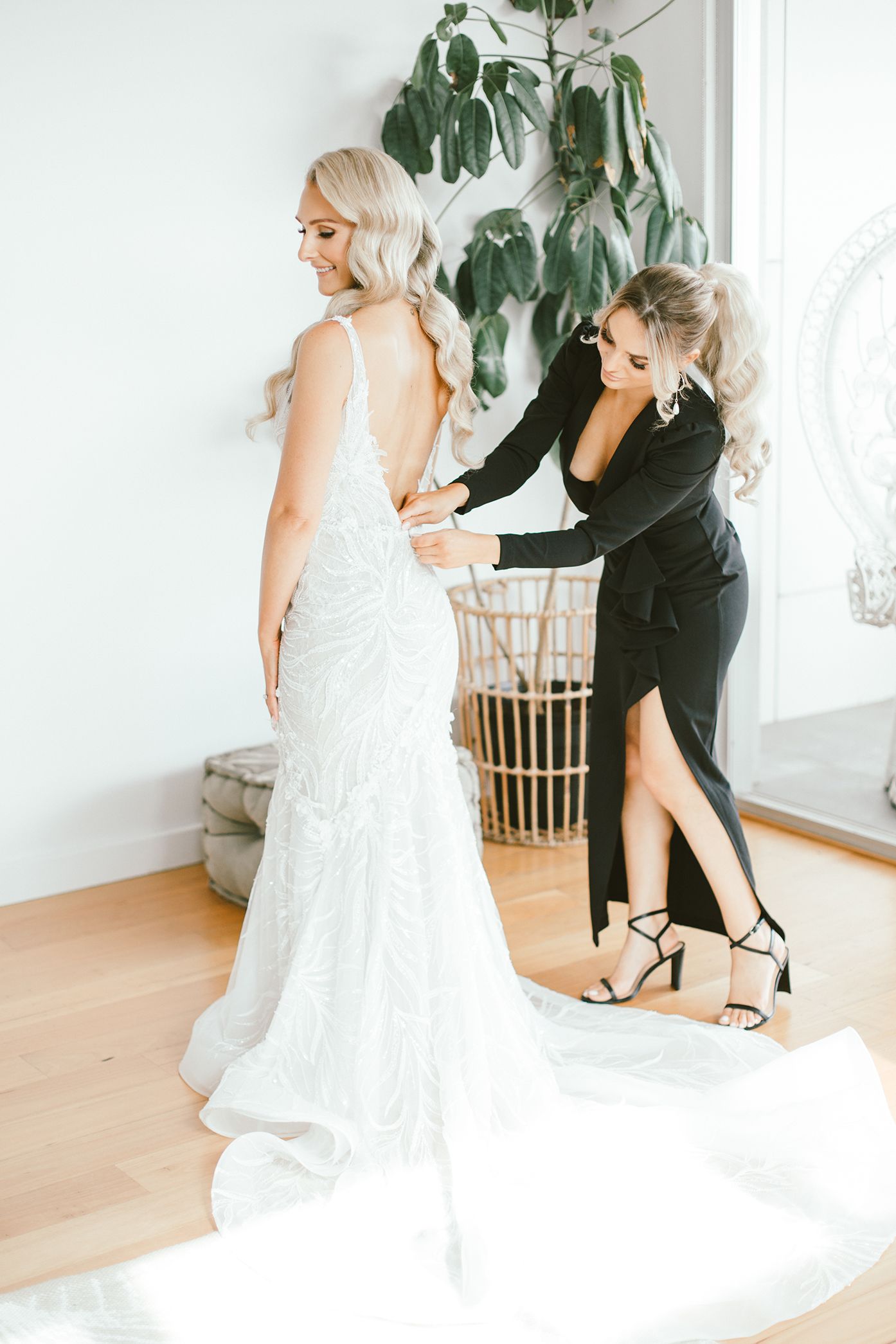 A final wedding dress fitting takes place in a bright modern room with indoor plants.