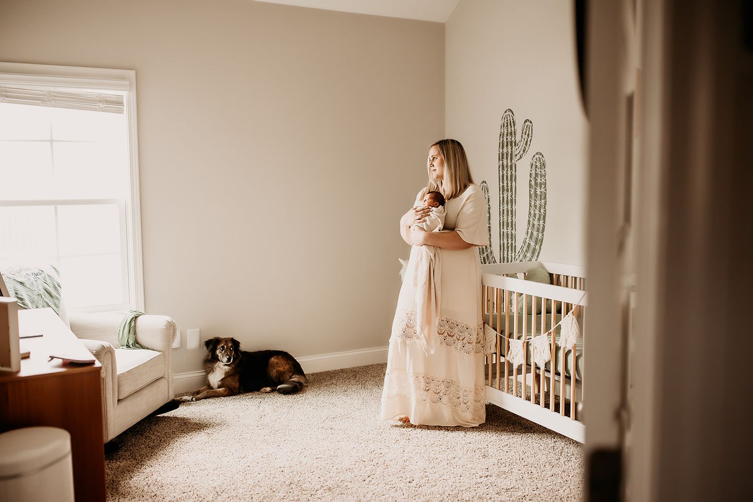 A mother holds her baby boy while standing in his nursery.