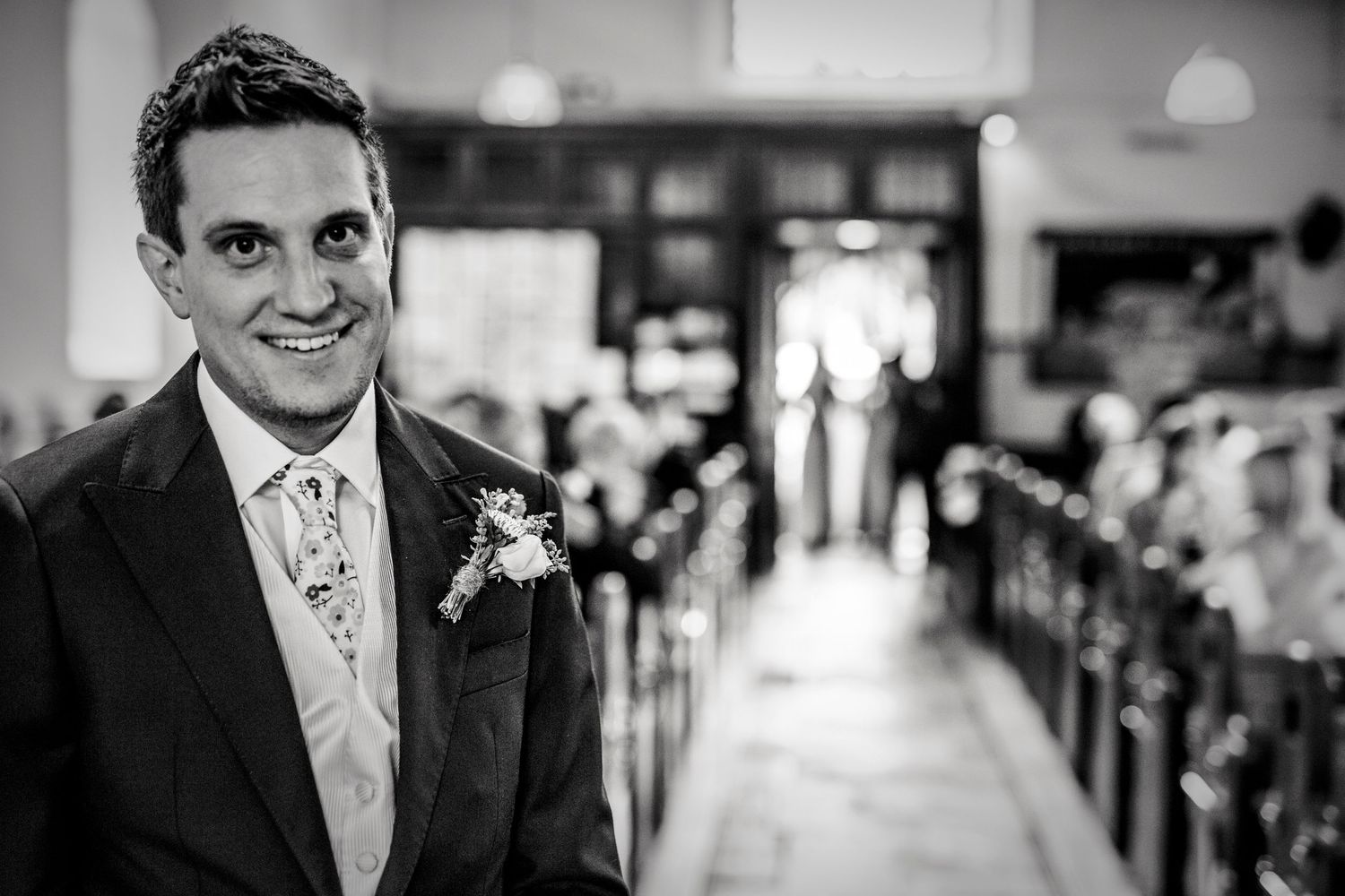 Wedding guests seated in church pews during an indoor ceremony.