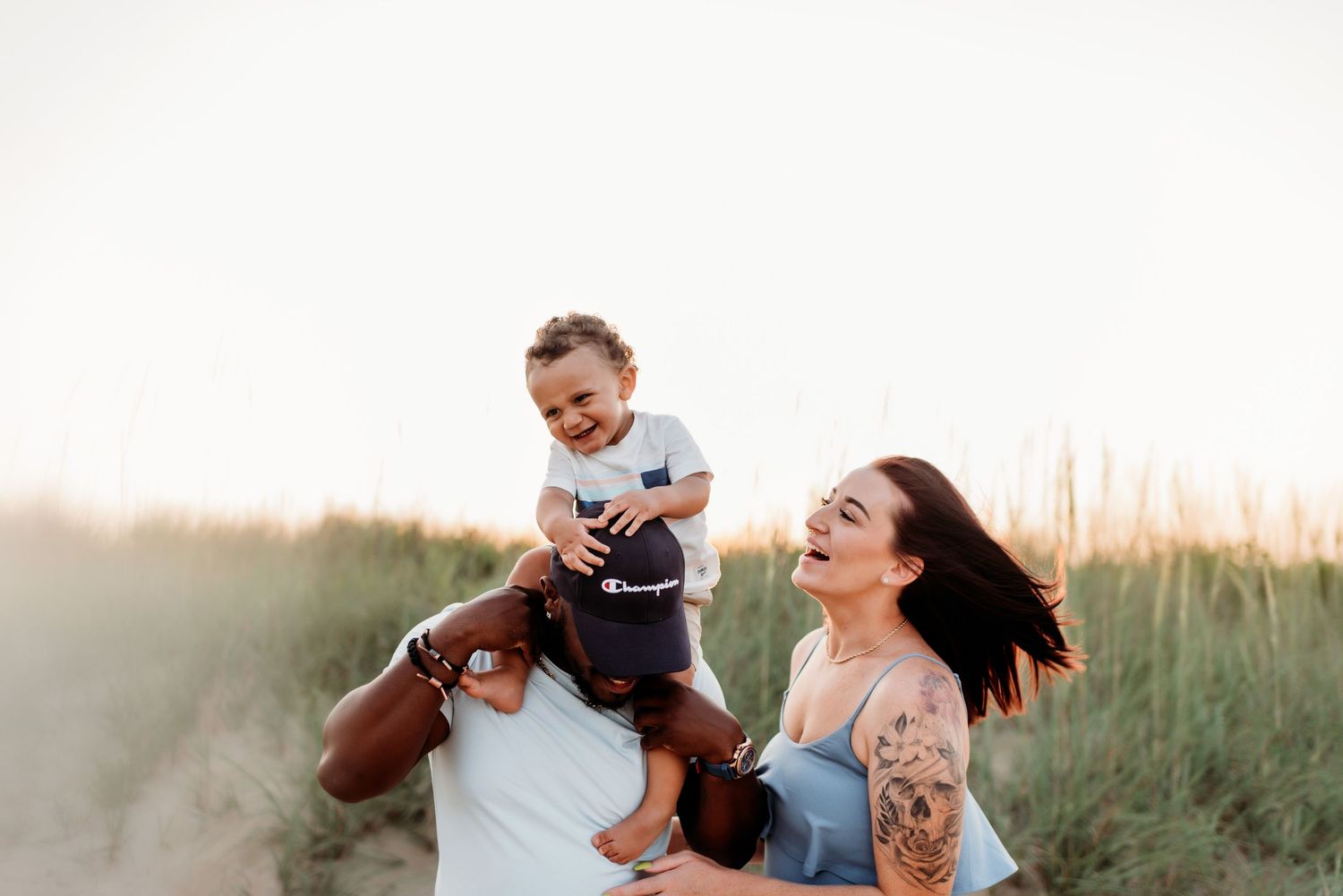 Candid laughing family portrait taken outdoors during golden hour.