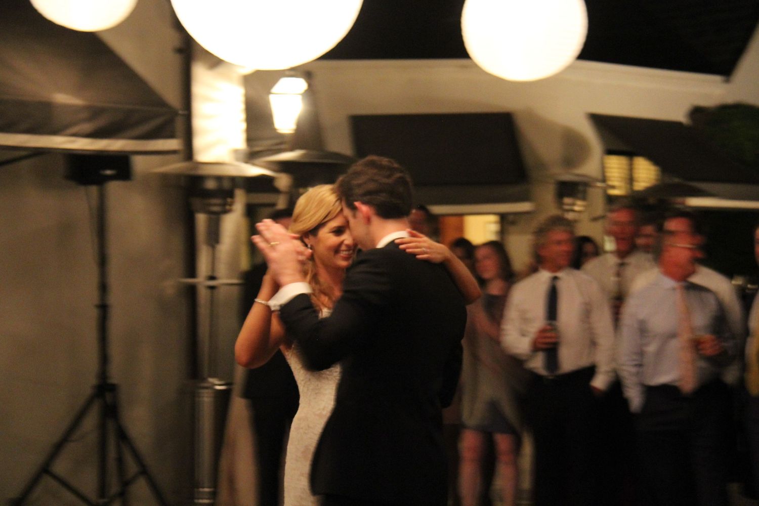 First dance moment captured under glowing paper lanterns at evening reception.