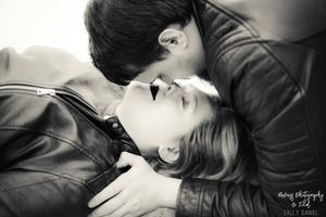 A romantic black and white portrait of a couple sharing an intimate moment.