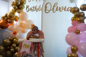 Festive birthday celebration setup with gold lettering and balloon arch decorations.