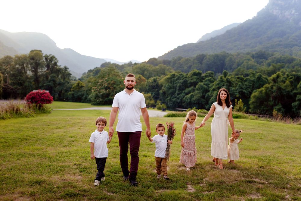 Family walking together hand in hand through a mountain valley at sunset.
