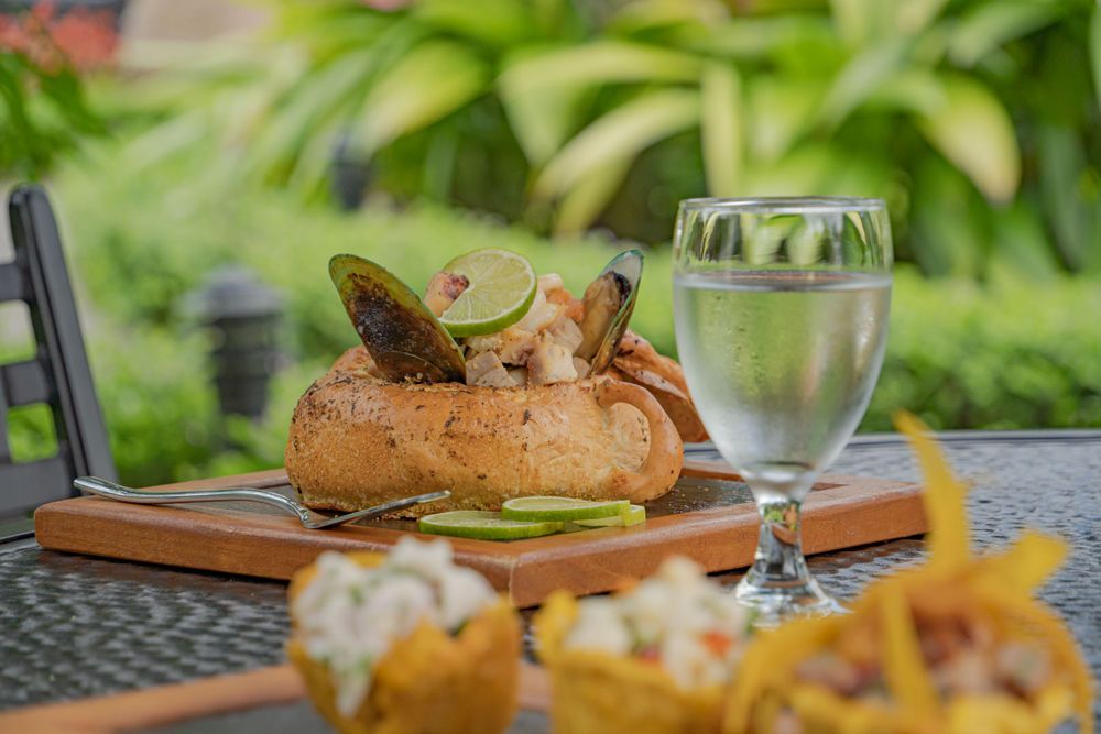 Fresh seafood and appetizers arranged on wooden serving boards at an outdoor restaurant.