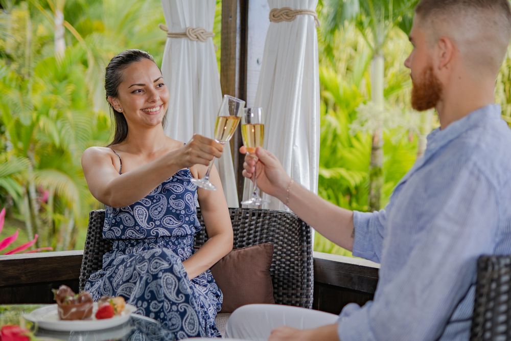 Couple enjoying a romantic outdoor dining experience on a tropical patio.