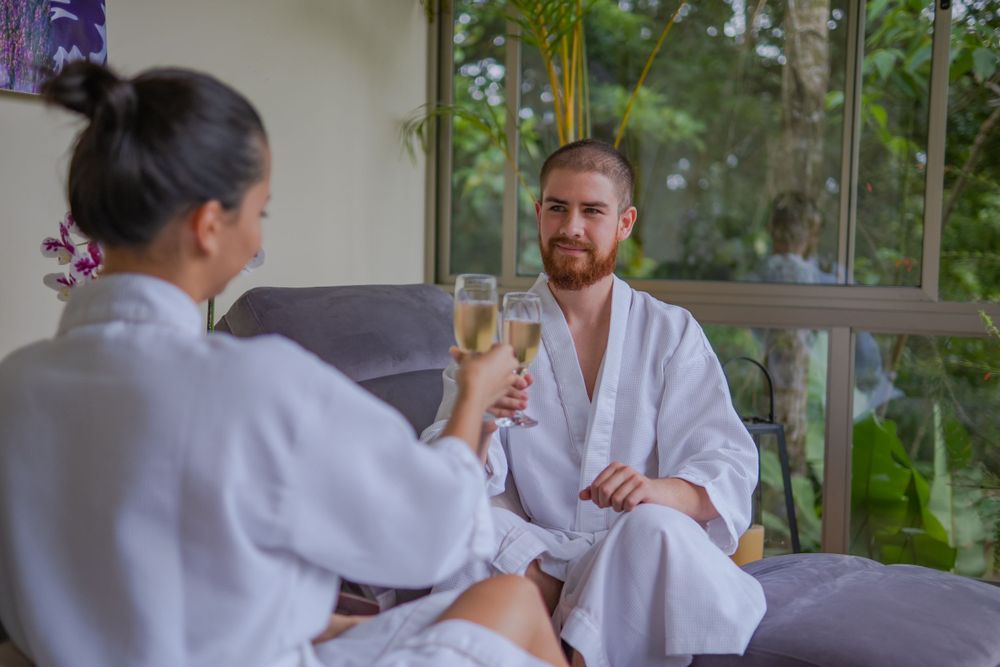 Spa treatment room with massage tables and tropical garden views.