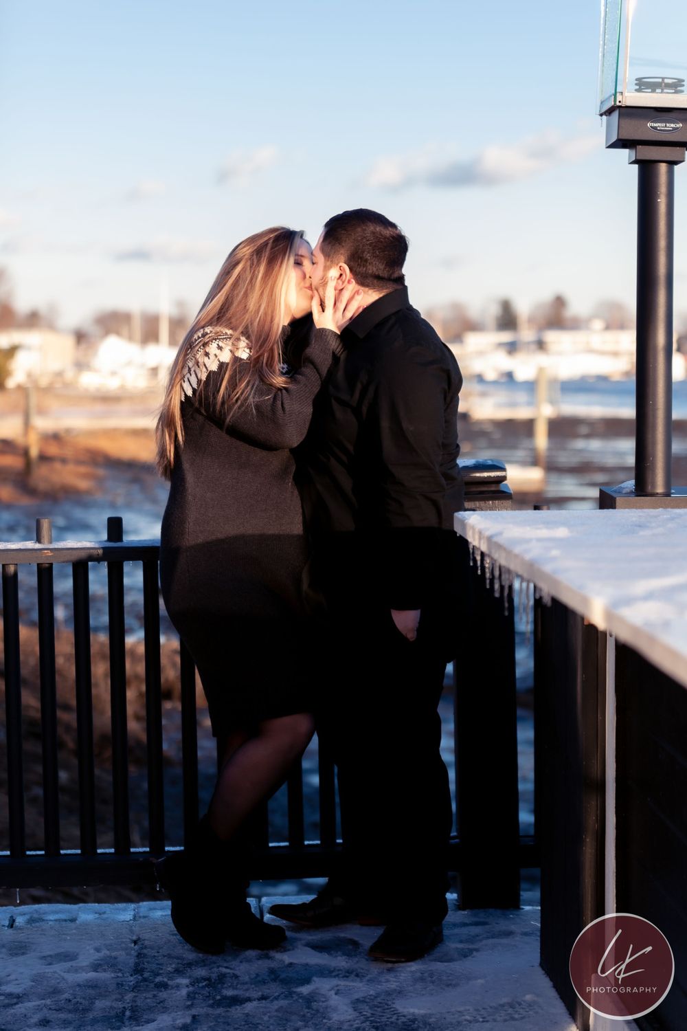 engaged couple kiss by the wickford harbor