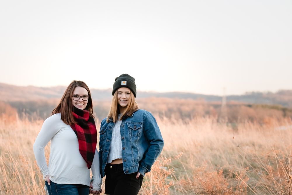 sisters best friends photo in an open field carhartt golden hour