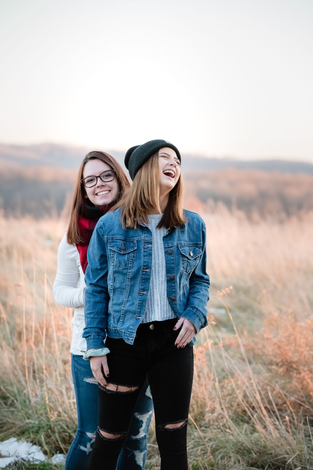 sisters best friends photo in an open field carhartt golden hour
