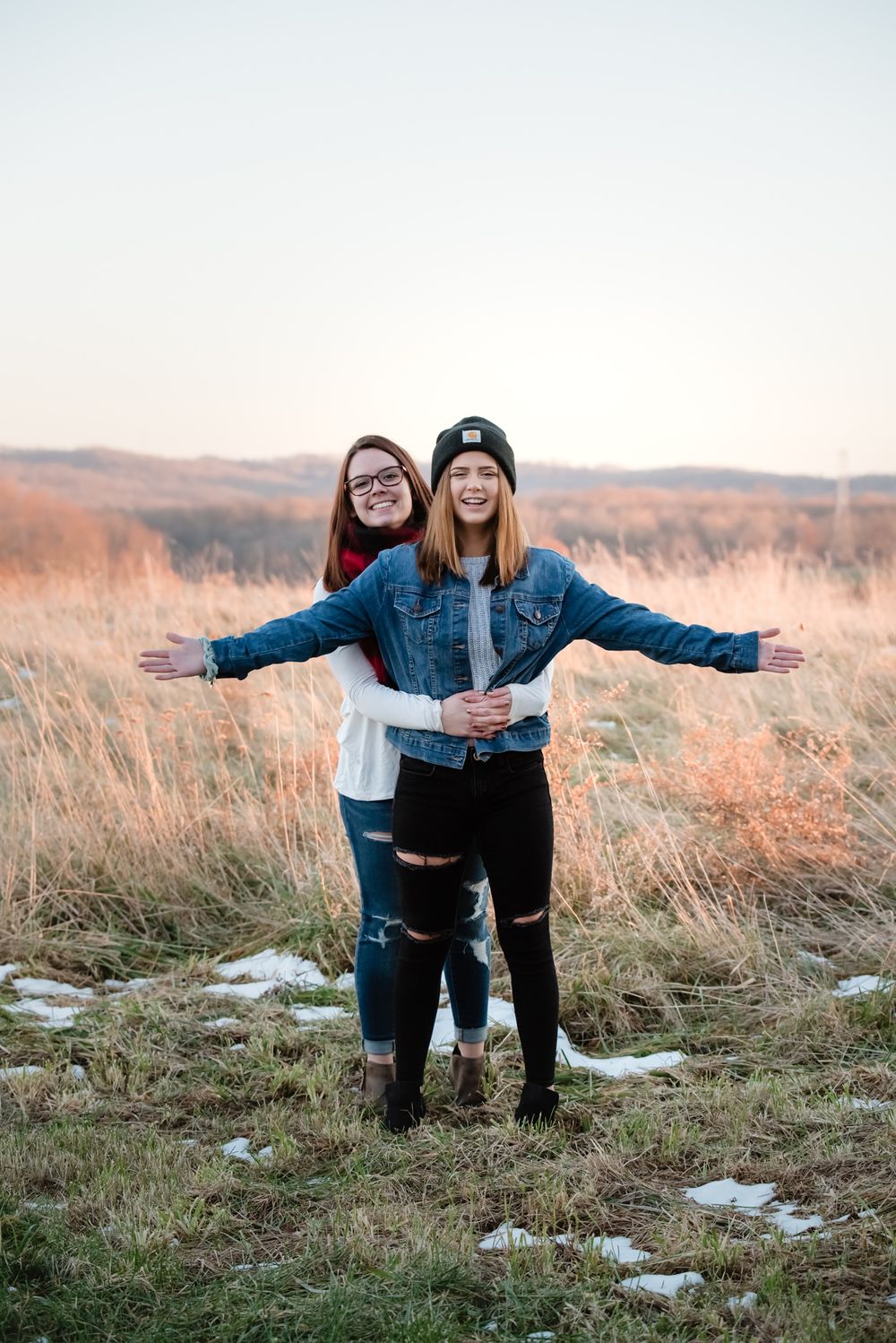 sisters best friends photo in an open field carhartt golden hour