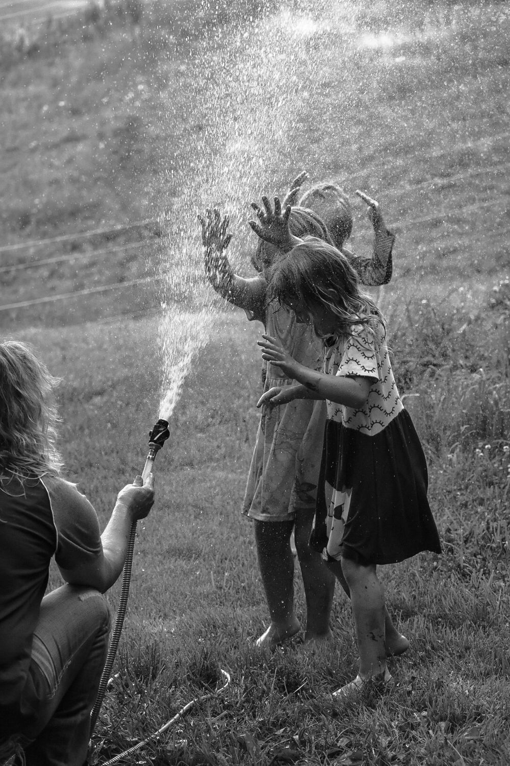 kids playing with a water hose in summer
