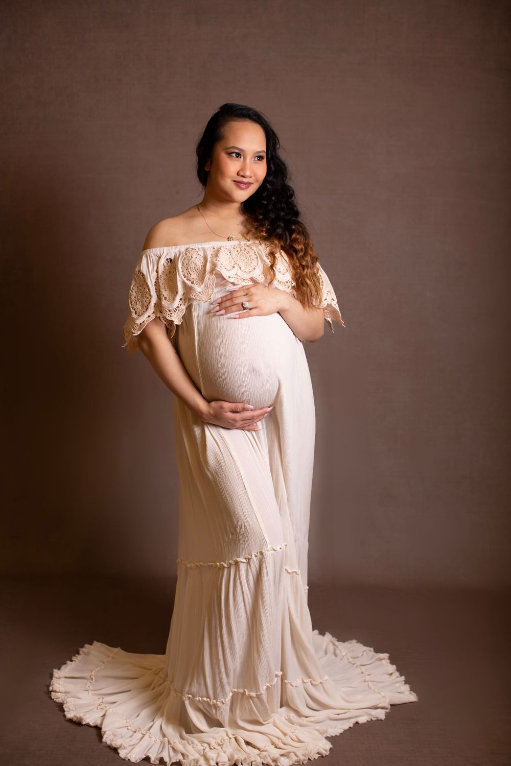 Romantic maternity portrait in off-shoulder lace dress with flowing train.