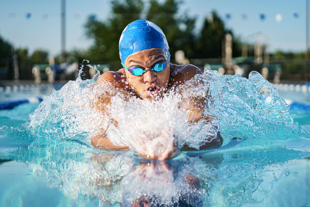 black male swims breaststroke