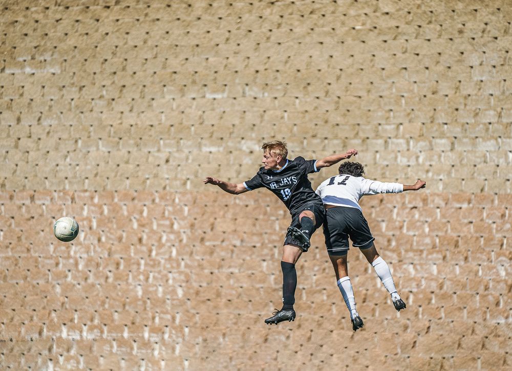 soccer players jump for ball