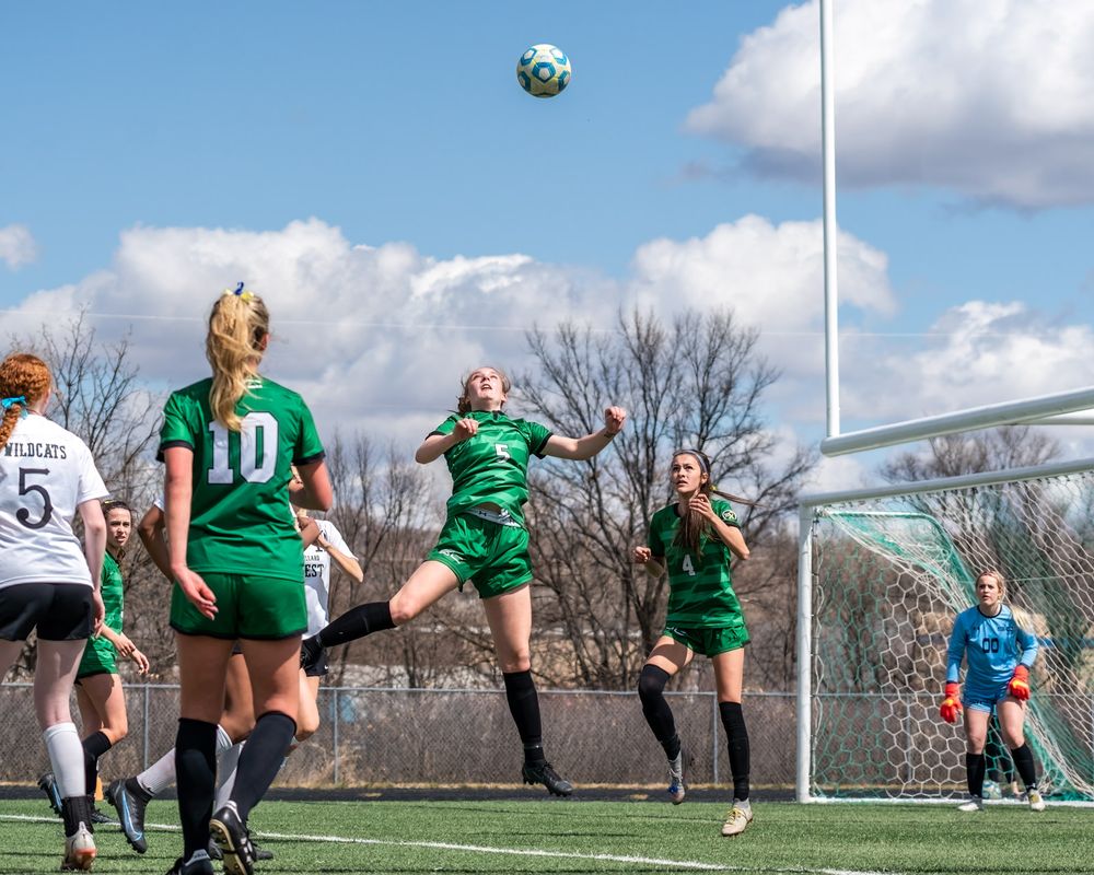 soccer female heads the ball