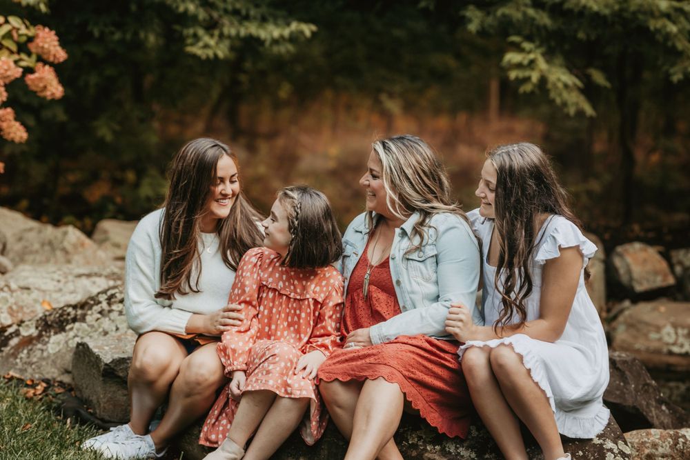 A group shares laughter while sitting together on rocky terrain during autumn.